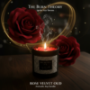 Rose Velvet Oud aromatic soy candle in a black jar with a lit flame, surrounded by red roses and soft golden light effects.